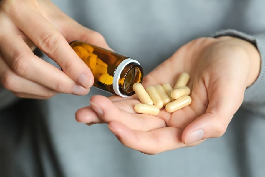 Zinek tablety v ruce – správná zinek denní dávka, jak dlouho užívat zinek a rozdíl mezi zinek chelát a zinek bisglycinát