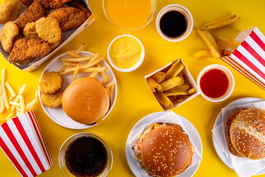 Různé druhy fastfoodu bohaté na omega-6 mastné kyseliny – hranolky, kuřecí nugety, burgery a smažená jídla, která mohou zvyšovat nepoměr mezi omega-6 a omega-3 ve stravě